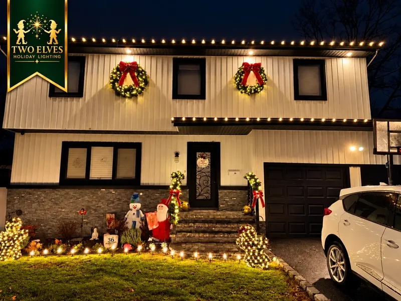 Two-story home with roofline lights, wreaths and lit garland railings